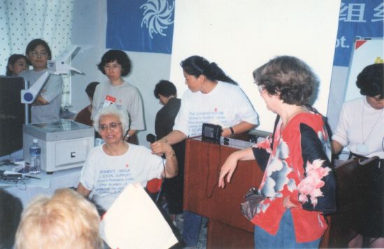 1995年北京世妇会,身着白色T恤、一头白发的王行娟在主持一场活动。图 | 受访者提供 1995年北京世妇会,身着白色T恤、一头白发的王行娟在主持一场活动。图 | 受访者提供