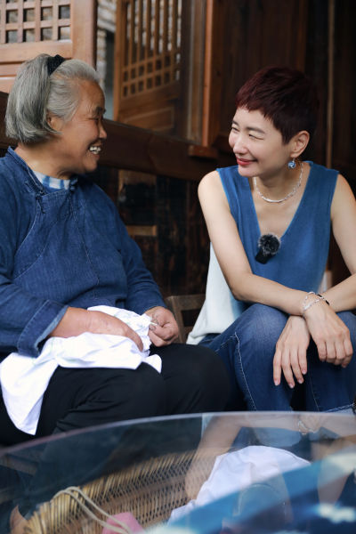 2024年,在贵州荔波的布依族古寨,晓雪与扎染手艺人互动交流。图|受访者提供 2024年,在贵州荔波的布依族古寨,晓雪与扎染手艺人互动交流。图|受访者提供