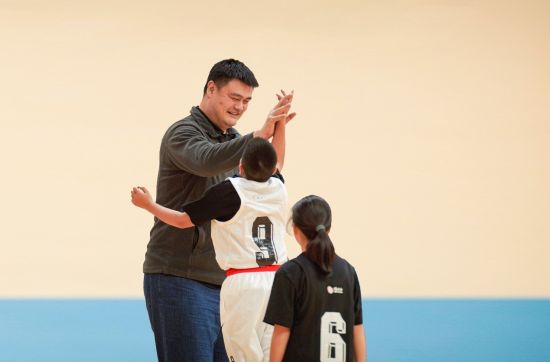 姚明与“篮球季”项目受益学生击掌庆祝