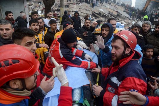 当地时间2月6日，土耳其地震后，人们从废墟中救出一名幸存者。