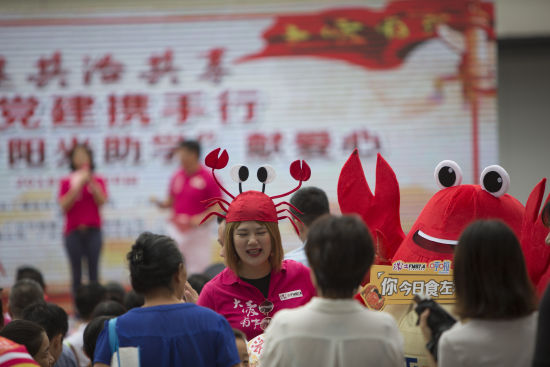 2018年8月28日上午，广州越秀区华乐街举办“‘阳光助学’献爱心”活动。爱心商家除了捐赠，还带来了吉祥物为现场增添气氛。图/视觉中国