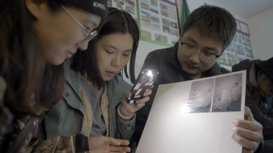 左起：魏春玥、邓雯洁、宋林，在查看雪豹影像。