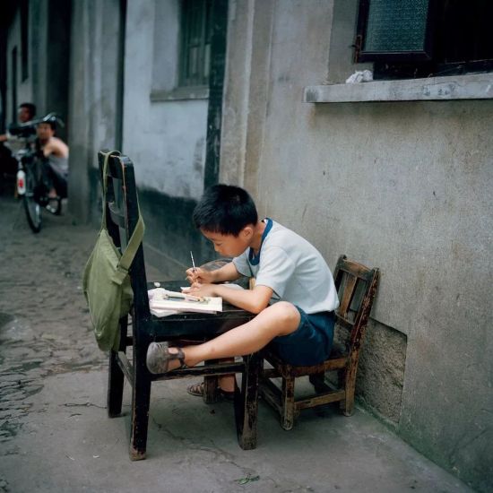 连日本摄影师都赞叹说，“中国果然是一个文字的国家啊，小朋友们都爱读书，真拼呀！”看来爱学习这件事是祖传的，不分年代。