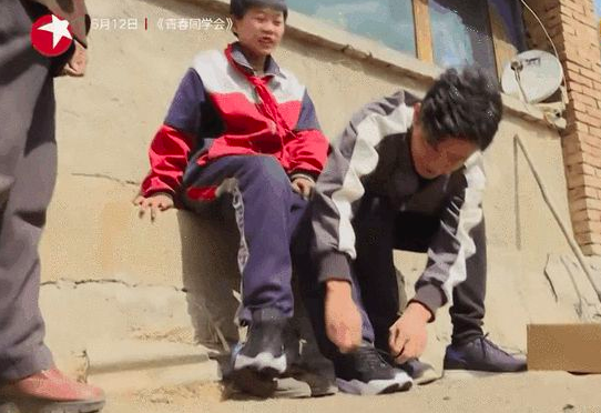 王宝强送男孩新鞋，并亲自帮他系鞋带。