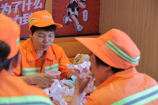 武汉环卫工人在派乐汉堡店内用餐，爱心餐包含一个汉堡、一根鸡肉卷、一份小食、一杯饮品。
