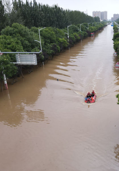 8月5日，涿州市城市道路路面积水深度达2米，救援人员驾驶救生艇开展救援。摄影/温如军
