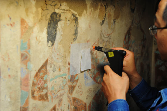 2013年7月15日，工作人员正在对莫高窟98号窟内壁画进行修复。